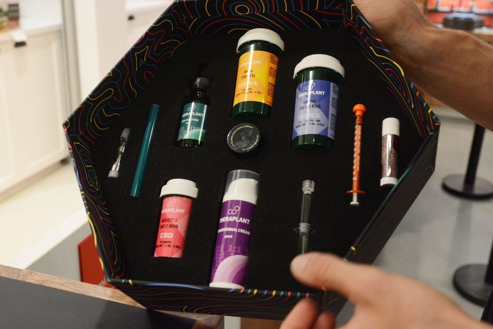 Shane Kelly, assistant manager and pharmacist at Fine Fettle medical marijuana dispensary, shows different forms of marijuana dosage forms including flower, vapes, concentrates, oral, creams and balms in Willimantic in this file photo. [John Shishmanian/ NorwichBulletin.com]