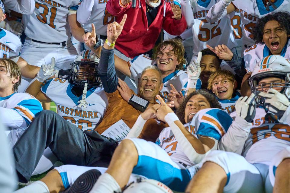 Nov 26, 2022; phoenix, az, usa; While being enveloped by his players, Eastmark head coach Scooter Molander poses for a photo after the Firebirds won the 3A AIA State Championship at Desert Vista High School’s football field in Phoenix on Saturday, Nov. 26, 2022. Mandatory Credit: Alex Gould/The Republic