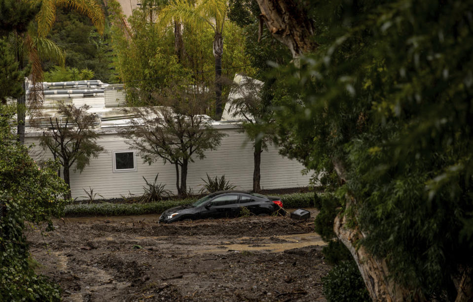 A car submerged by a mudslide Tuesday, Feb. 6, 2024, in the Beverly Crest area of Los Angeles. (AP Photo/Ethan Swope)