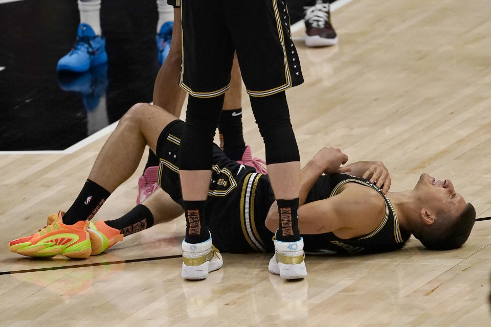 Atlanta Hawks guard Bogdan Bogdanovic (13) lies on the court after an injury during the first half of Game 6 of an NBA basketball Eastern Conference semifinal series against the Philadelphia 76ers, Friday, June 18, 2021, in Atlanta. Bogdanovic stayed in the game. (AP Photo/John Bazemore)