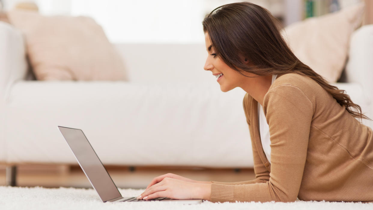 Smiling woman working with laptop at home.