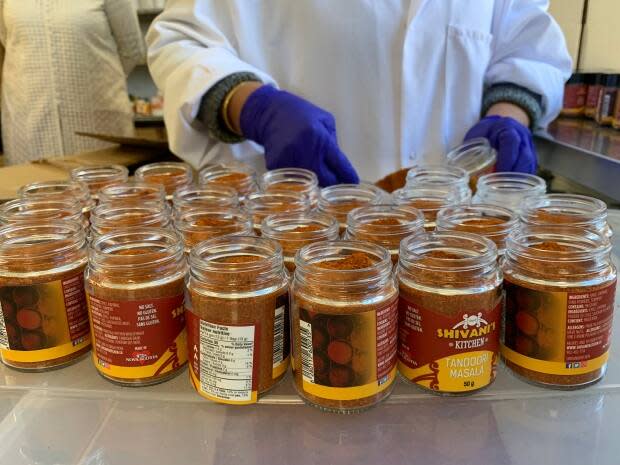 Workers packaging spice mixes by hand in Shivani's Kitchen.