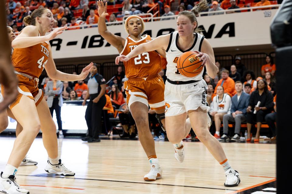 Jan 20, 2024; Stillwater, Okla, USA; Oklahoma State Cowgirls forward Lior Garzon (12) drives past Texas Longhorns forward Aaliyah Moore (23) in the second half of a womenÕs NCAA basketball game at Gallagher Iba Arena. Mandatory Credit: Mitch Alcala-The Oklahoman. Mandatory Credit: Mitch Alcala-The Oklahoman