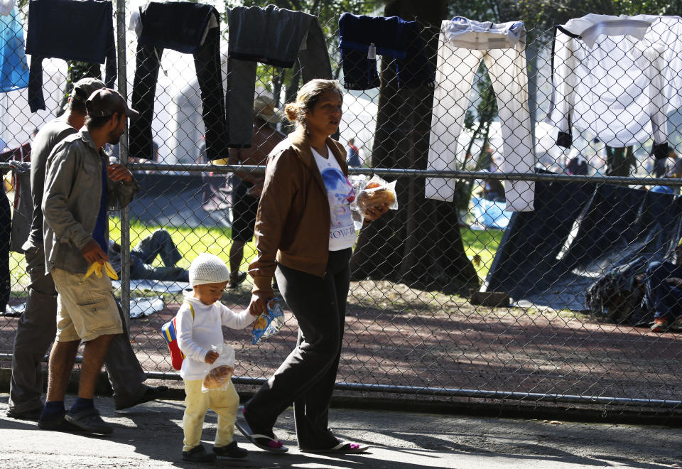 Central American migrants take shelter at the Jesus Martinez stadium in Mexico City, Tuesday, Nov. 6, 2018. Humanitarian aid converged around the stadium in Mexico City where thousands of Central American migrants winding their way toward the United States were resting Tuesday after an arduous trek that has taken them through three countries in three weeks. (AP Photo/Marco Ugarte)