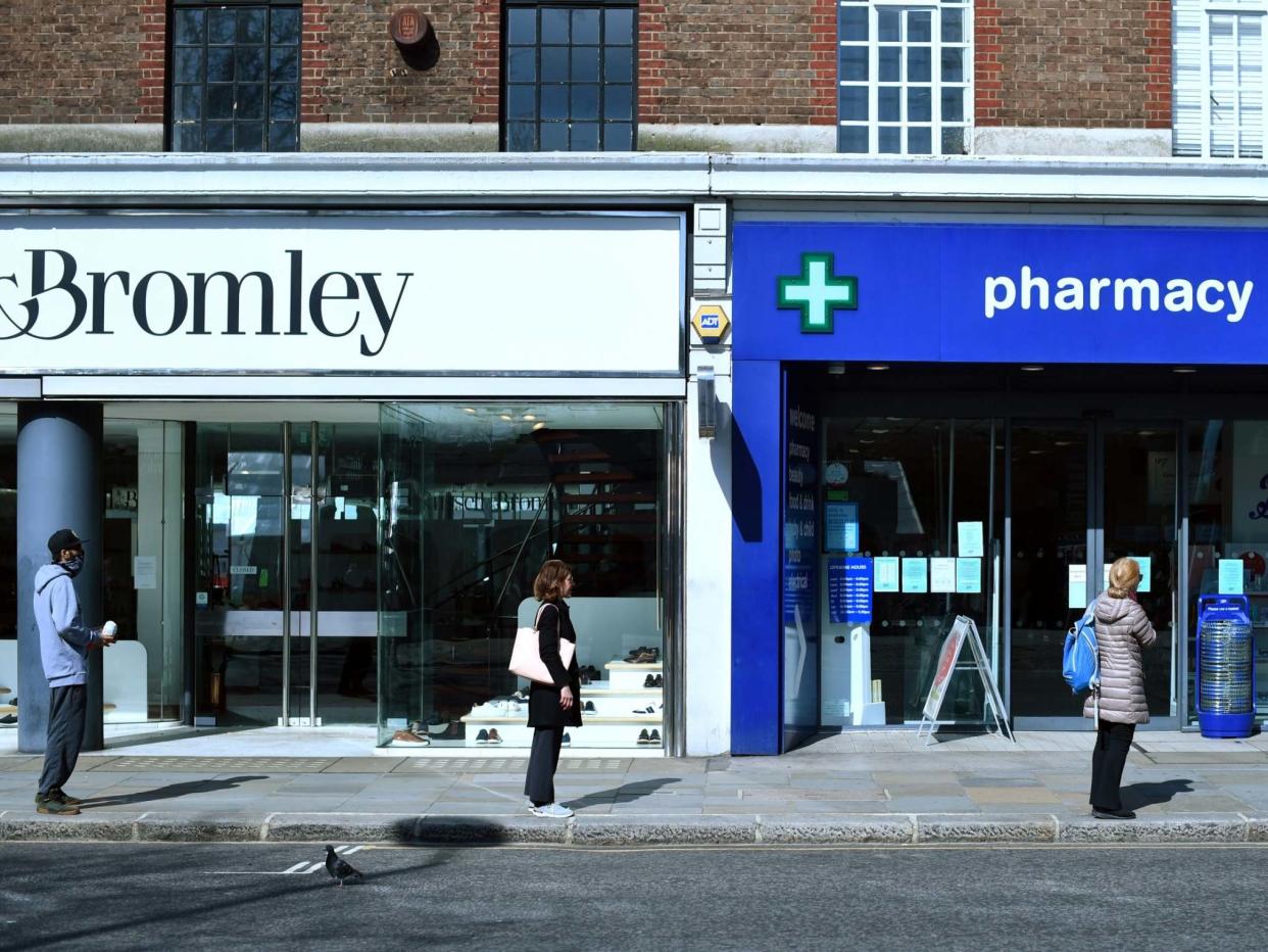 Customers queue up two metres apart for a pharmacy in London during the nationwide lockdown: REUTERS