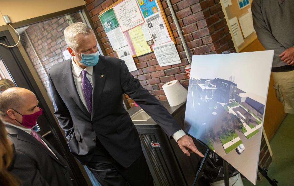 Gov. Charlie Baker examines a rendering of a planned new Father Bill's & MainSpring facility.