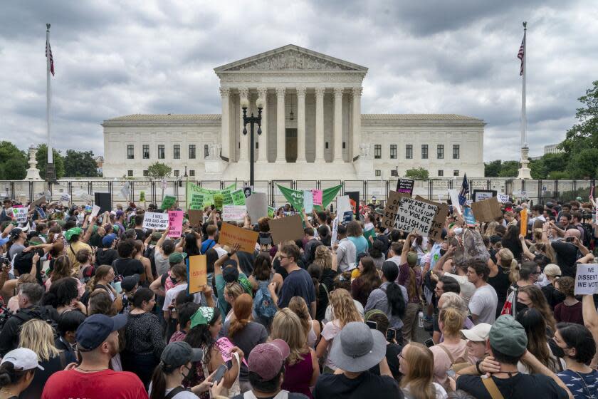 A large group of protestors gather outside a courthouse