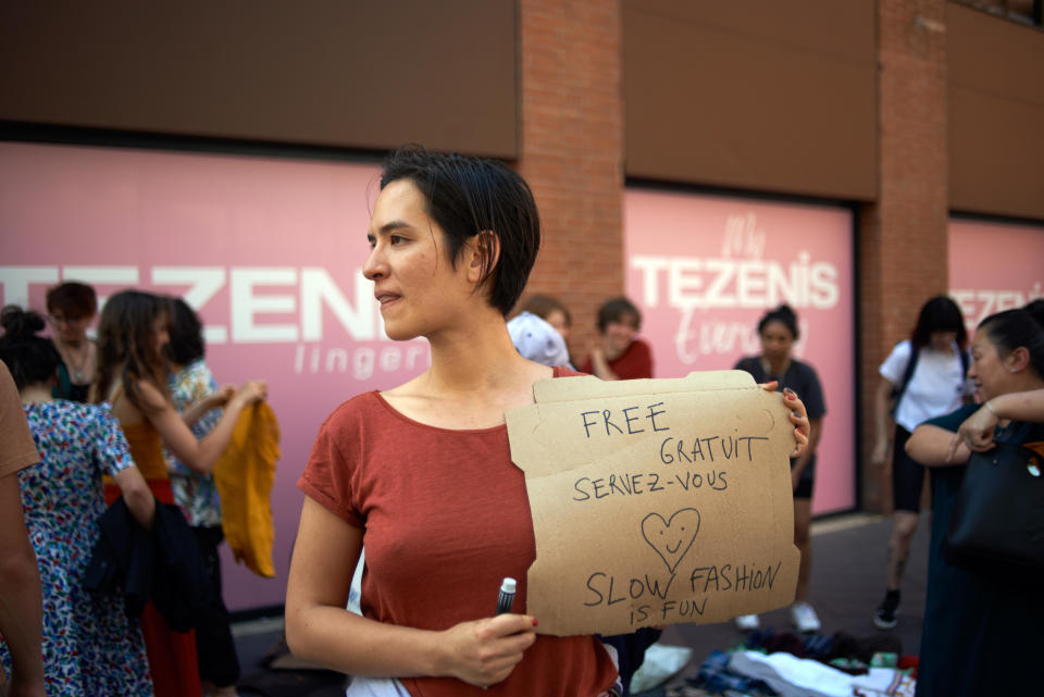 A young woman holds a cardboard reading 'Free, slow fashion is fun'. Members of XR Toulouse (Extinction Rebellion) organized a protest in front of a pop-up SHEIN shop. The Chinese brand SHEIN opened a pop-up store in Toulouse only for 4 days. XR wanted to raise awareness about water consumption and waste, over consumption of resources, workers' conditions and abuse of human rights in China. / Credit: Alain Pitton/NurPhoto via Getty Images