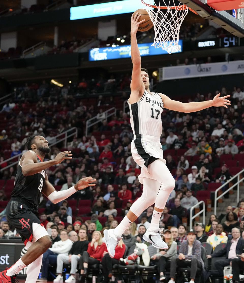 San Antonio Spurs forward Doug McDermott (17) drives to the basket past Houston Rockets forward Bruno Fernando (20) during the first half of an NBA basketball game, Monday, Dec. 19, 2022, in Houston. (AP Photo/Eric Christian Smith)