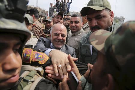 Iraq's Prime Minister Haider al-Abadi (C) tours the city of Tikrit after Iraq security forces regained control from Islamist State militants in this April 1, 2015 file photo. REUTERS/Stringer/Files