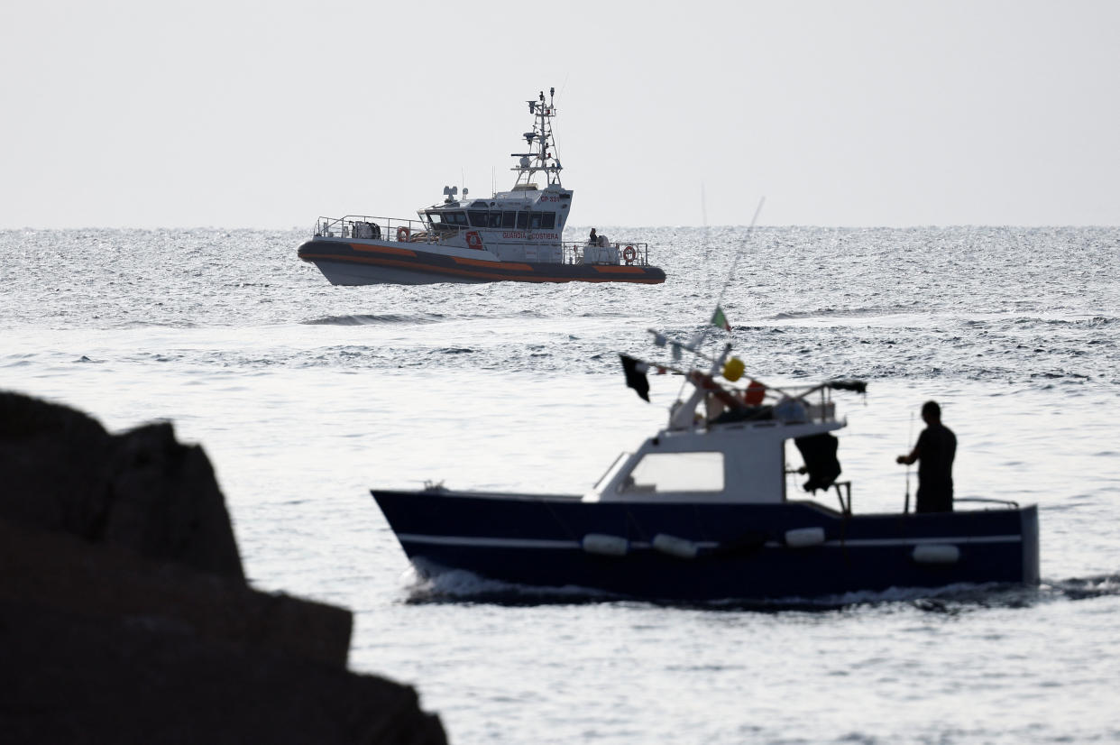 A fishing boat sails past a coast guard vessel operating in the sea to search for the missing, including British entrepreneur Mike Lynch, after a luxury yacht sank off the coast of Porticello, near the Sicilian city of Palermo, Italy, August 20, 2024. REUTERS/Guglielmo Mangiapane