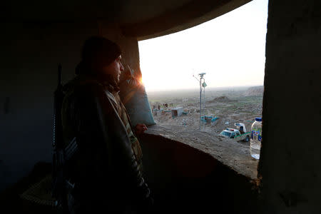 A Popular Mobilisation Forces (PMF) fighter takes his position near the Iraqi-Syrian border in al-Qaim, Iraq, November 25, 2018. REUTERS/Alaa al-Marjani