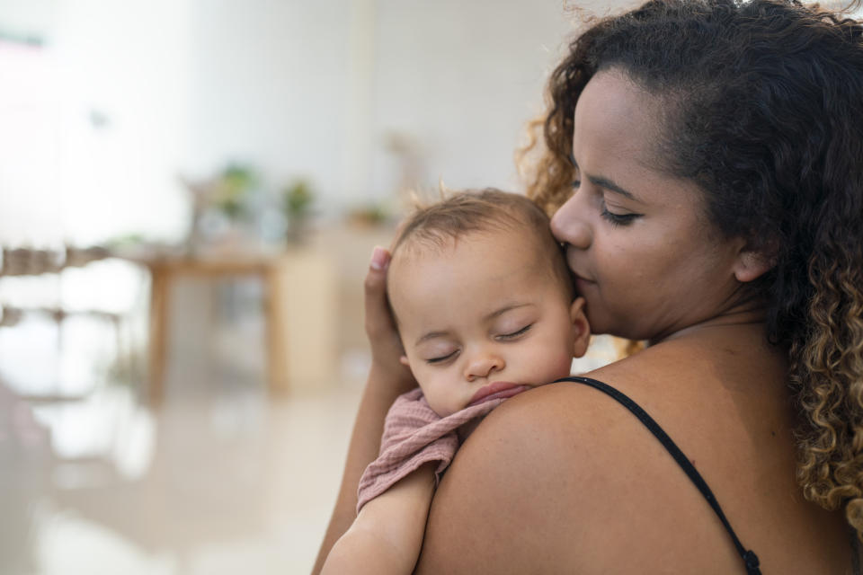 A woman kissing her baby on the head