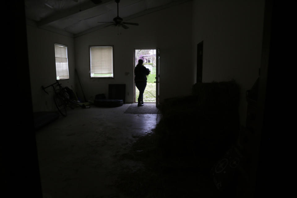 Alison Dreith carries hay out of her barn in rural southern Illinois on Wednesday, April 13, 2022. Dreith and her husband moved to the farm but are continuing to work remotely. Dreith works for the Midwest Access Coalition, which pays for "practical support" for women seeking abortions. That includes things like air fare, gas money, hotel rooms or child care. (AP Photo/Martha Irvine)