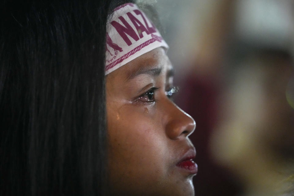 A devotee cries as she joins the "Walk of Faith" procession as part of celebrations for the feast day of the Black Nazarene, a centuries-old charred statue of Jesus Christ, on Sunday, Jan. 8, 2023, in Manila, Philippines. The annual Black Nazarene feast day which will be held on Jan. 9 draws massive numbers of devotees who pray for the sick and a better life in this predominantly Roman Catholic nation. (AP Photo/Aaron Favila)