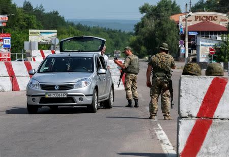 Ukrainian servicemen check cars at a checkpoint near Slaviansk in Donetsk region, Ukraine, June 29, 2016. Picture taken June 29, 2016. REUTERS/Gleb Garanich