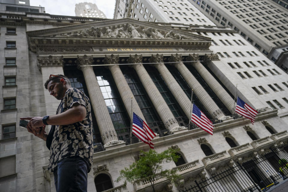 FILE - Pedestrians walk past the New York Stock Exchange, on July 8, 2022, in New York.  Stocks are opening lower on Wall Street Wednesday, Aug. 17,  as traders absorb some discouraging news about how much Americans are spending. (AP Photo/John Minchillo, file)