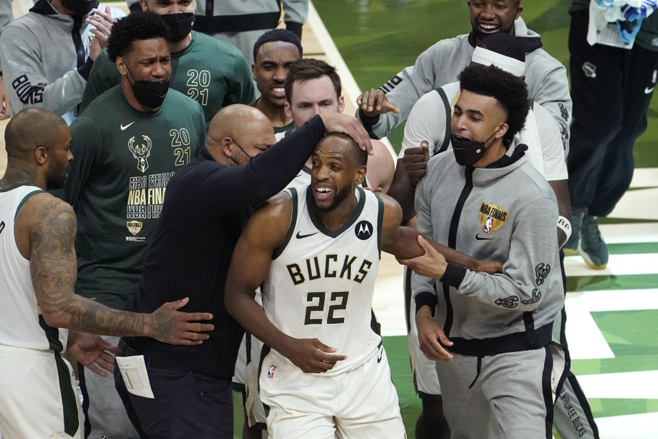 Milwaukee Bucks forward Khris Middleton (22) celebrates with teammates during the second half against the Phoenix Suns in Game 4 of basketball's NBA Finals in Milwaukee, Wednesday, July 14, 2021. (AP Photo/Paul Sancya)