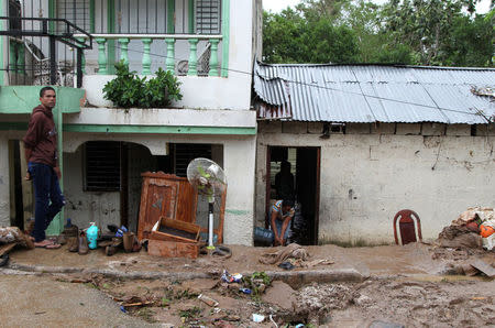 A woman sweeps mud out of a house flooded by an overflow of the Soco River in El Seibo, Dominican Republic, September 22, 2017. REUTERS/Ricardo Rojas