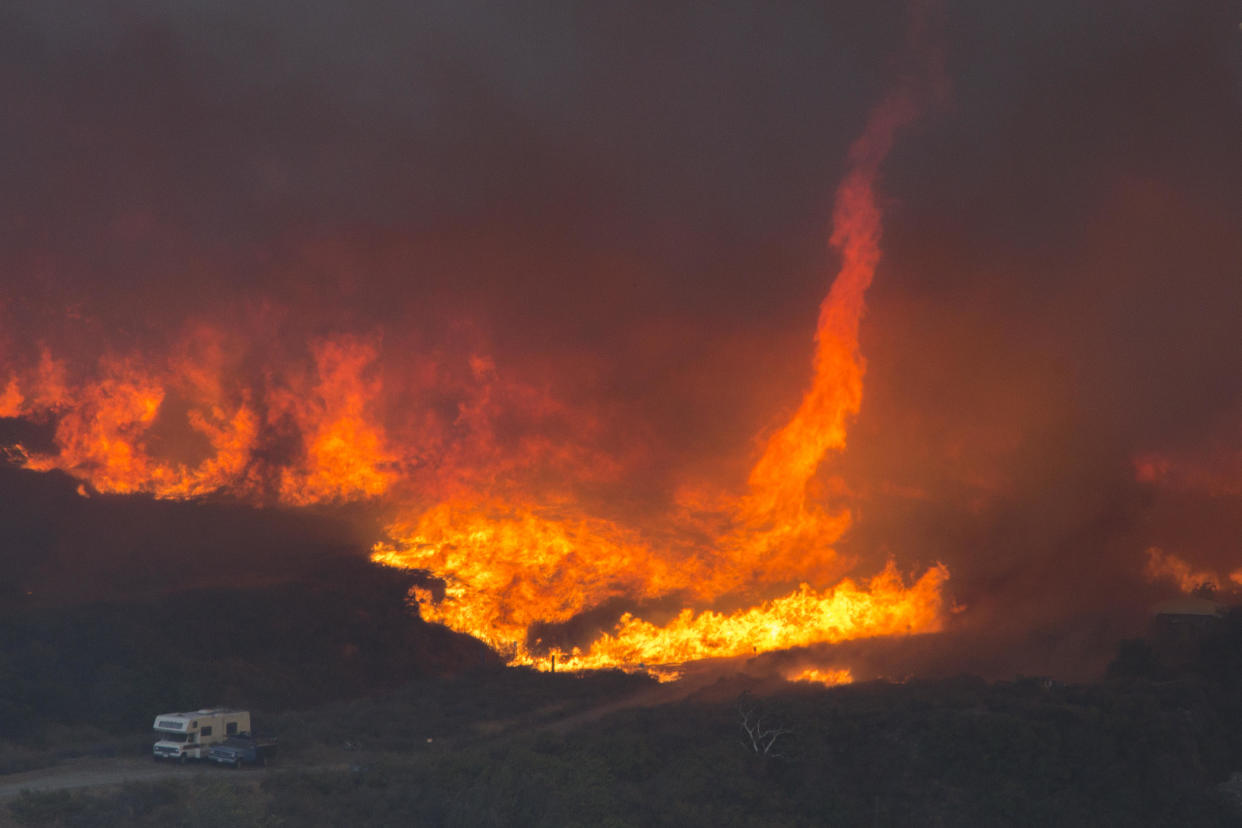 A fire tornado forms near cars parked on a country road at the Blue Cut Fire on August 17, 2016 near Wrightwood, California. / Credit: David McNew / Getty Images