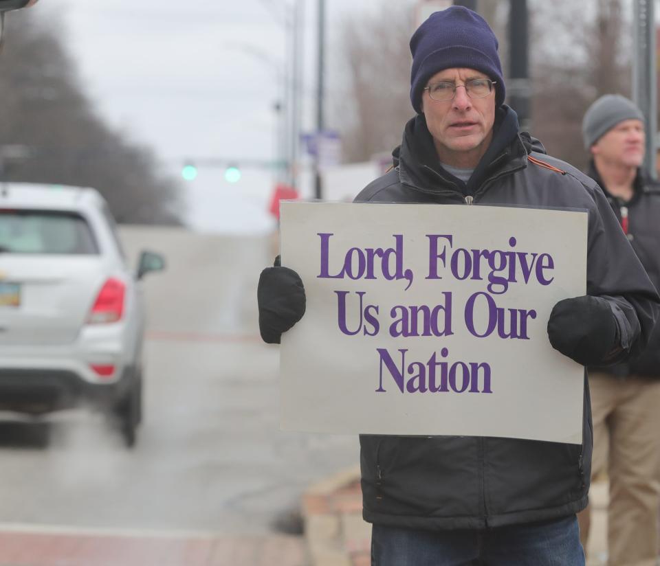 An anti-abortion activist stands in front of the Northeast Ohio Women's Center during the Summit County March for Life in Cuyahoga Falls.