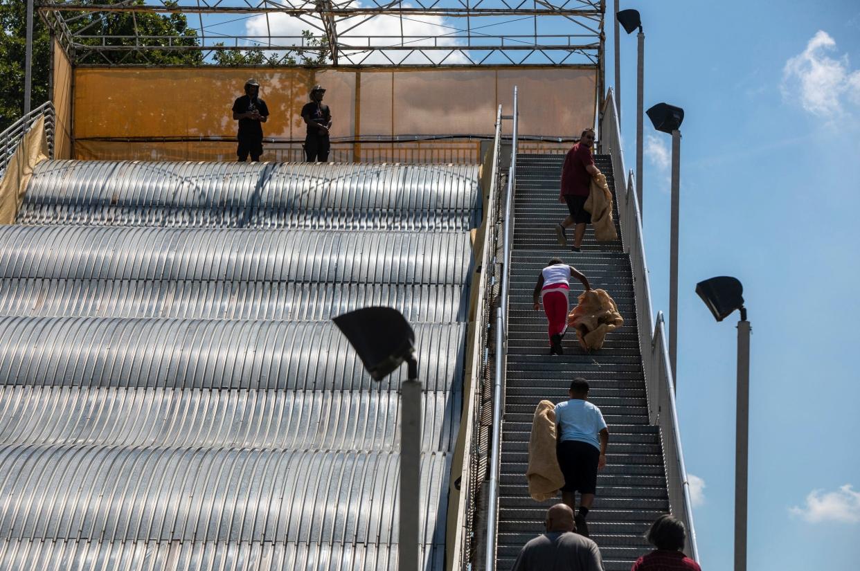 People climb the stairs of the giant slide at Belle Isle Park in Detroit on Aug. 19, 2022.