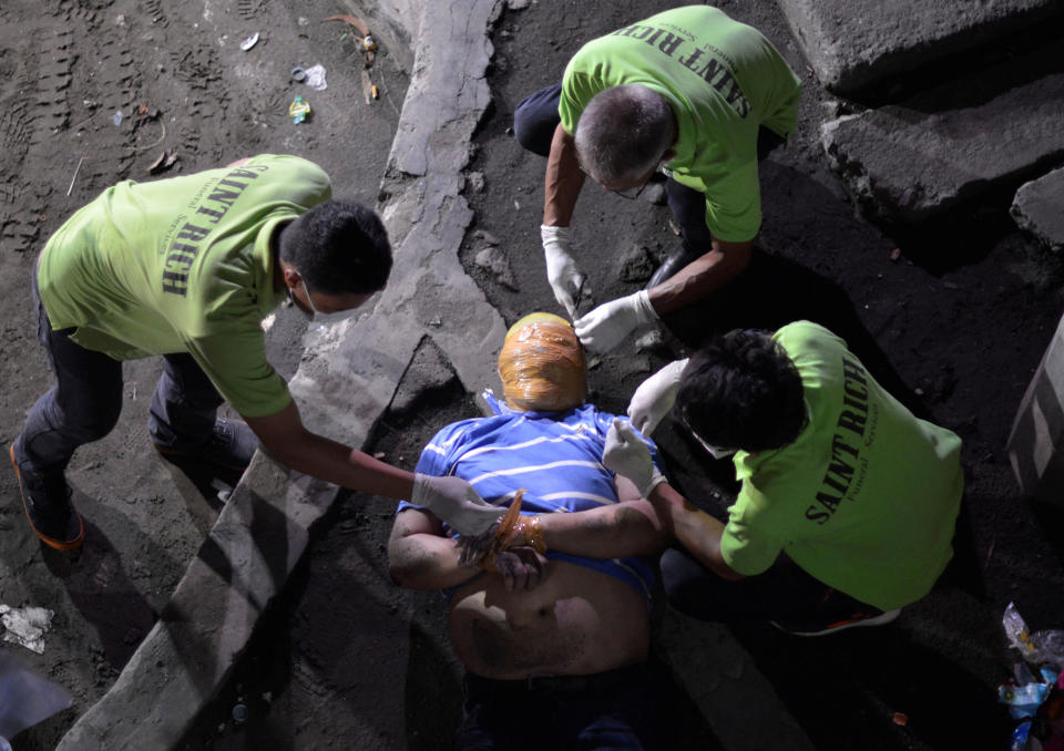 <p>Funeral workers remove the masking tape wrapped around the head and the wrists of the body of a man, who police said is a victim of drug related vigilante execution in Manila, Philippines on Sept. 21, 2016. (REUTERS/Ezra Acayan) </p>