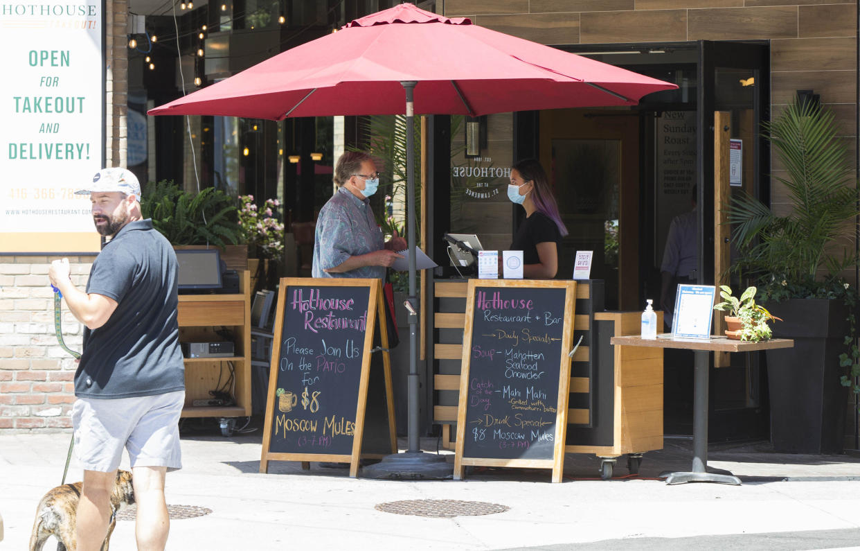  A customer wearing a face mask waits to dine in at a restaurant in Toronto, Canada