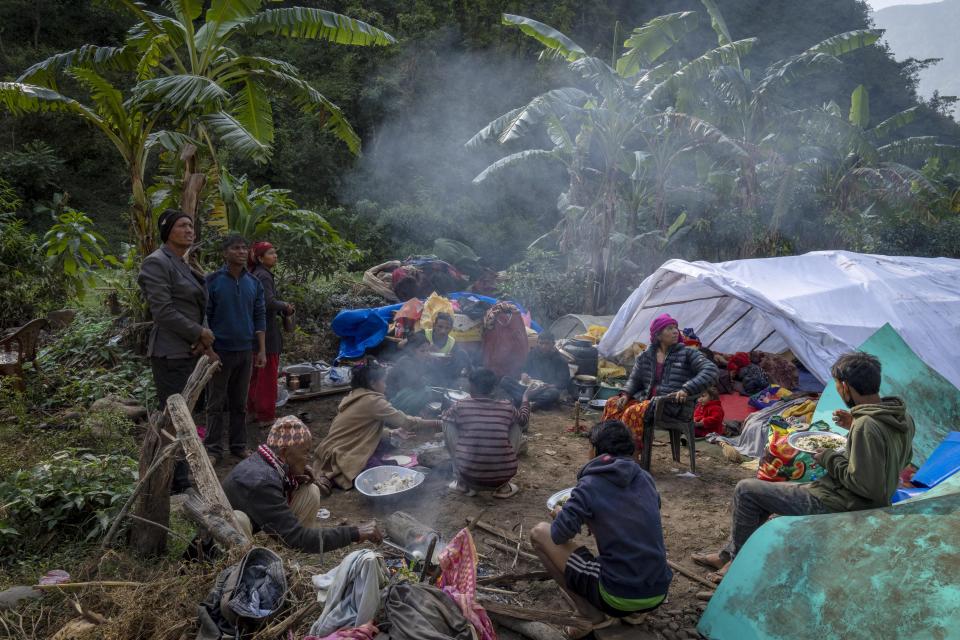 Earthquake survivors have food in the open in Rukum District, northwestern Nepal, Monday, Nov. 6, 2023. The Friday night earthquake in the mountains of northwest Nepal killed more than 150 people and left thousands homeless. (AP Photo/Niranjan Shrestha)