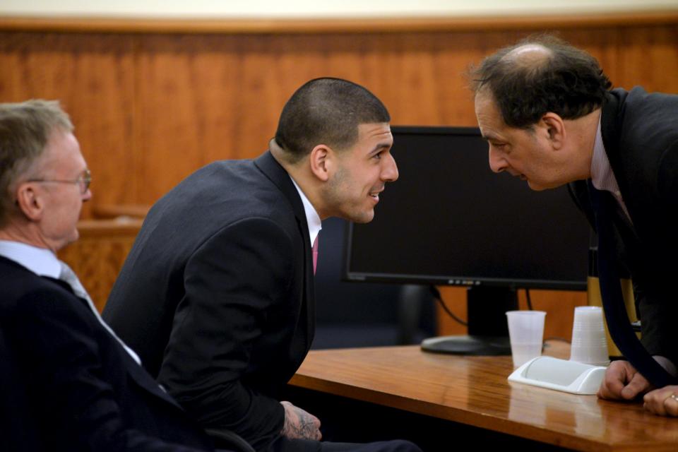 Former New England Patriots football player Hernandez speaks with Defense Attorney Sultan and Defense Attorney Rankin looks on as they wait in the courtroom of the Bristol County Superior Court House in Fall River