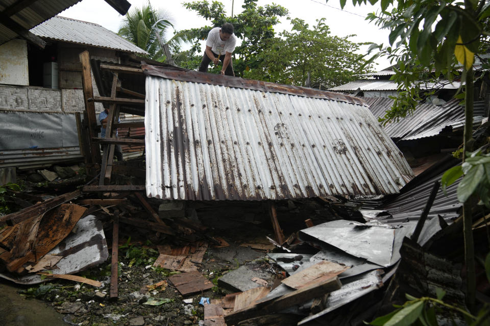 Edwin Decacada tries to salvage materials on Monday, Oct. 24, 2022, from the newly demolished house of his brother at the coastal village of Anibong, an area badly hit by super Typhoon Haiyan when it struck the province nine years ago, in Tacloban city, central Philippines. About 40% of the population of Tacloban was relocated to safer areas after super Typhoon Haiyan wiped out most of the villages, killing thousands when it hit central Philippines in 2013. (AP Photo/Aaron Favila)