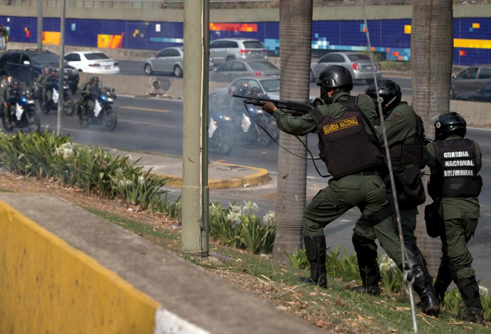 Bolivarian National Guards soldiers fire rubber bullets toward demonstrators during clashes at an anti-government protest in Caracas, Venezuela, Saturday, April 26, 2014. Student organizers at the last minute decided against marching downtown to avoid a confrontation with security forces in the government-controlled district. Instead they concentrated in the wealthier, eastern neighborhoods that have been the hotbed of unrest since February. (AP Photo/Fernando Llano)