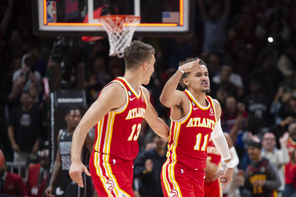 Atlanta Hawks guard Bogdan Bogdanovic, left, and guard Trae Young react after buzzer-beater during the second half of an NBA basketball game against the Brooklyn Nets, Sunday, Feb. 26, 2023, in Atlanta. (AP Photo/Hakim Wright Sr.)