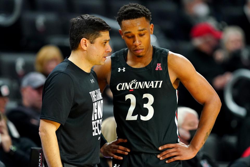 Cincinnati Bearcats head coach Wes Miller talks with Cincinnati Bearcats guard Mika Adams-Woods (23) in the second half of an NCAA menÕs college basketball game against the Houston Cougars, Sunday, Feb. 6, 2022, at Fifth Third Arena in Cincinnati. The Houston Cougars defeated the Cincinnati Bearcats, 80-58. 