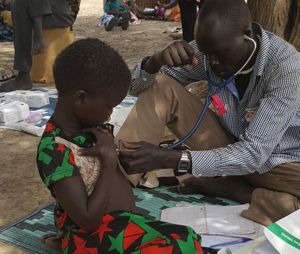 An MSF community health worker examines a 4-year-old girl suffering from malnutrition. (Photo: Nicolas Peissel/MSF)