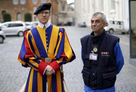 Roberto, a homeless man who lives around Vatican, poses with a Swiss guard before entering the Vatican March 26, 2015. REUTERS/Max Rossi