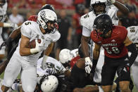 Central Florida running back Isaiah Bowser (5) attempts to get past an oncoming rush by Louisville safety Shavarick Williams (30) during the first half of an NCAA college football game in Louisville, Ky., Friday, Sept. 17, 2021. (AP Photo/Timothy D. Easley)