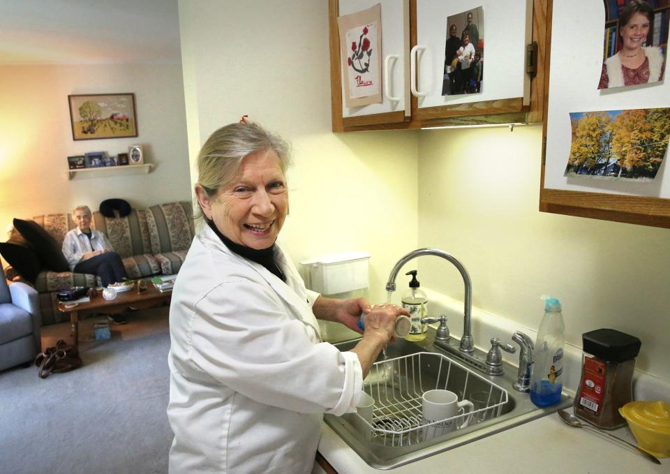 Jean Kerr of Chefs for Seniors cleans after cooking in client Dorothy Richmond's apartment.