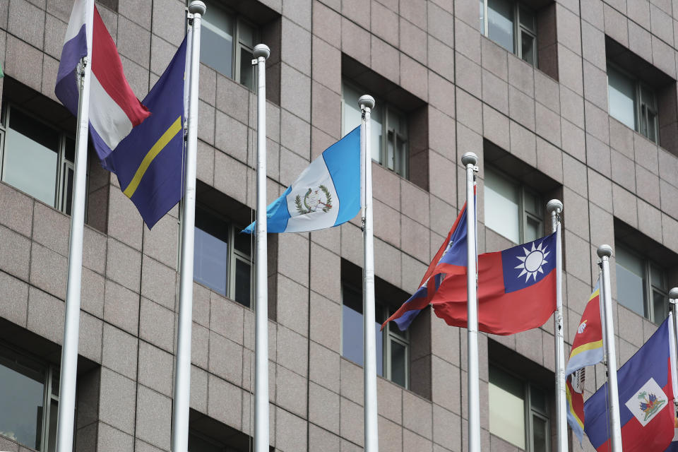 The Guatemalan national flag, center left, flies next to a pole left vacant by the Honduran national flag, outside the Diplomatic Quarter building in Taipei, Taiwan, Sunday, March 26, 2023. Honduras formed diplomatic ties with China on Sunday after breaking off relations with Taiwan, which is now recognized by only 13 sovereign states. (AP Photo/Chiang Ying-ying)