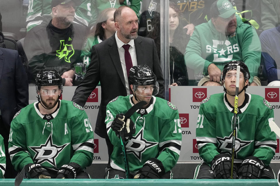 Dallas Stars' Tyler Seguin (91), Craig Smith (15), and Jason Robertson (21) sit on the bench in front of manager Peter DeBoer, center top, in the final seconds of the third period of an NHL hockey game against the Winnipeg Jets in Dallas, Thursday, April 11, 2024. (AP Photo/Tony Gutierrez)