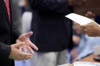 A job seeker talks with a corporate recruiter as he peruses the man's resume at a Hire Our Heroes job fair in Washington