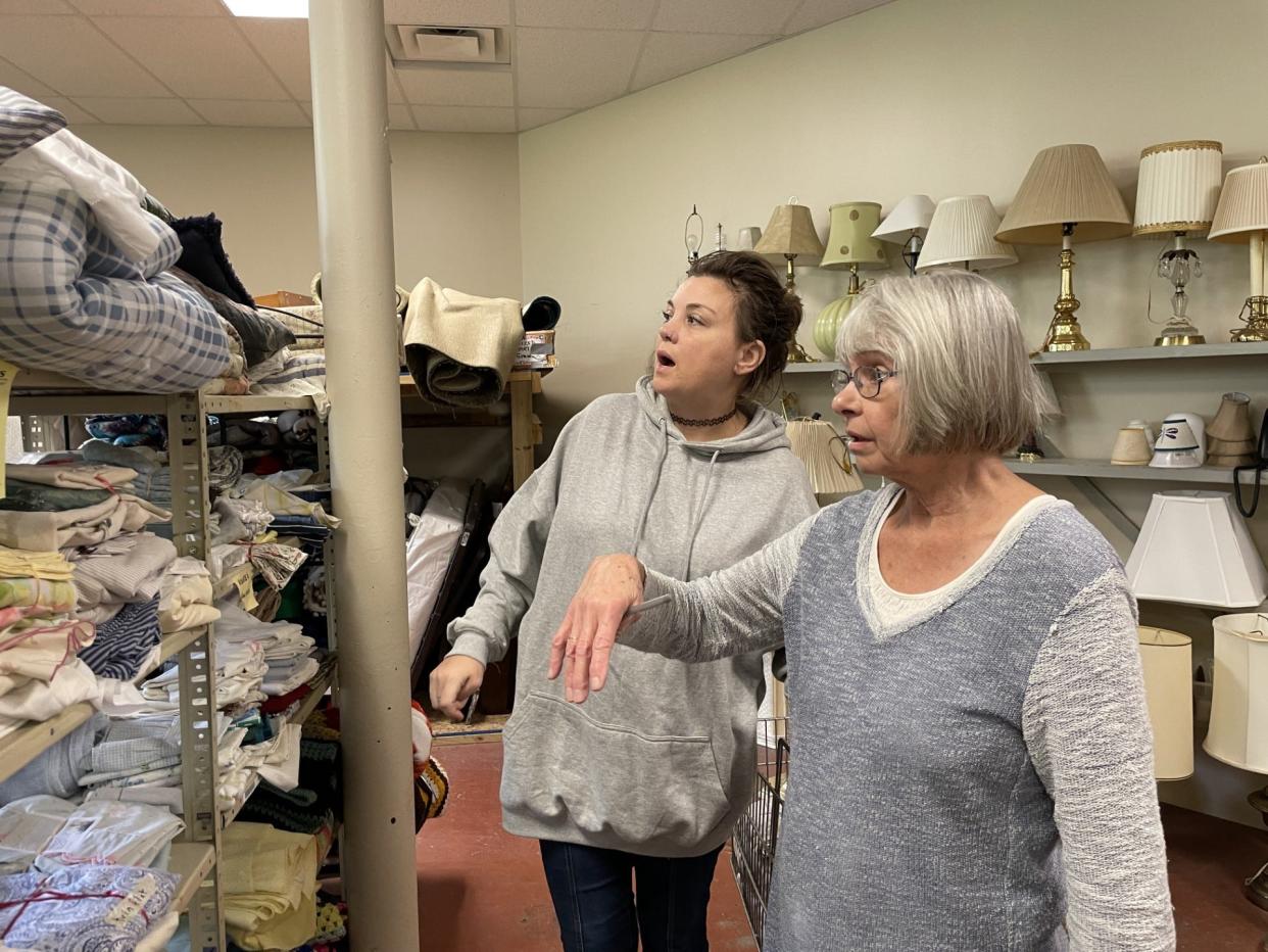 Client Rebecca McGlynn (left) looks at bedding with In the Spirit of Giving volunteer Gwen Marlow. McGlynn, who has health problems, was able to get many household items from the ministry.