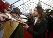 Actor Jared Leto, from the film "Dallas Buyers Club," signs an autograph as he arrives at the 20th annual Screen Actors Guild Awards in Los Angeles, California January 18, 2014. REUTERS/Mario Anzuoni (UNITED STATES - Tags: ENTERTAINMENT) (SAGAWARDS-ARRIVALS)