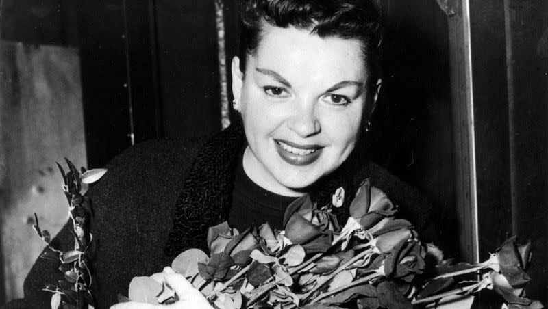 Judy Garland poses with long-stemmed roses in her arms as she arrives in New York City on Sept. 17, 1956.