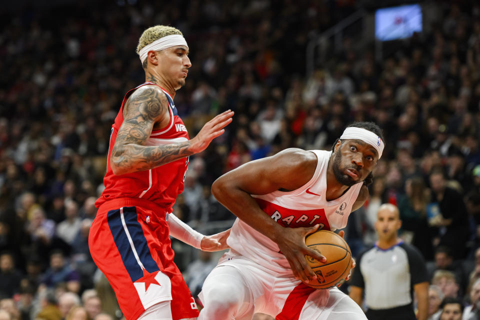 Toronto Raptors forward Precious Achiuwa, right, is guarded by Washington Wizards forward Kyle Kuzma, left, during second-half NBA basketball game action in Toronto, Monday, Nov. 13, 2023. (Christopher Katsarov/The Canadian Press via AP)