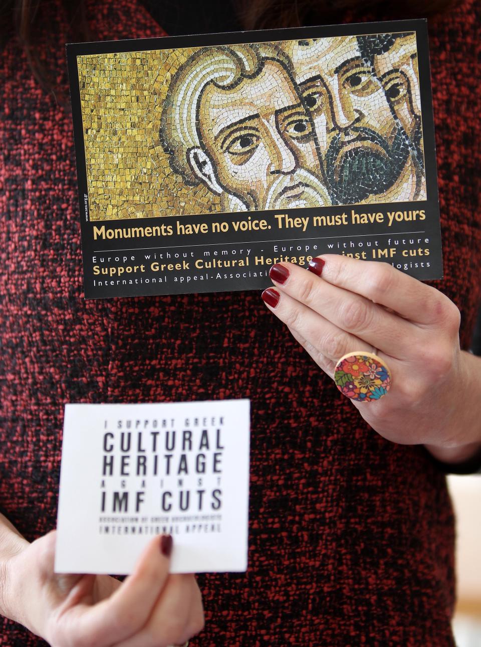 A Greek archaeologist union leader holds flyers against the impact of austerity measures on the country's rich cultural heritage during a press conference in Athens, Wednesday, March 14, 2012. Union representatives said illegal excavations have increased, and claimed that despite two high-profile thefts from Greek museums the government is planning to reduce spending on museum security. (AP Photo/Thanassis Stavrakis)