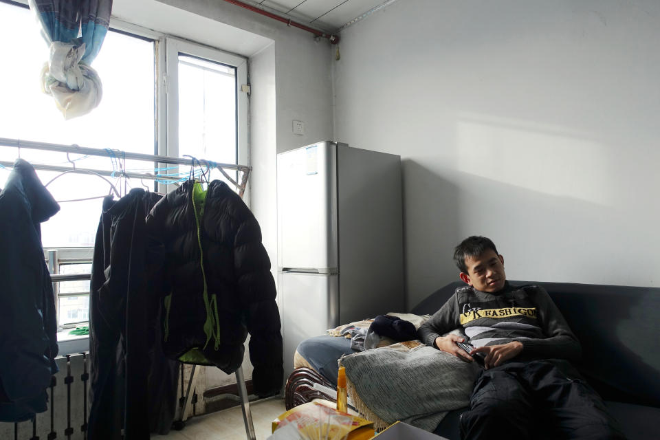 Ship mechanic Li Hai, 32, sits inside his flat during an interview with Reuters, in the coal city of Hegang