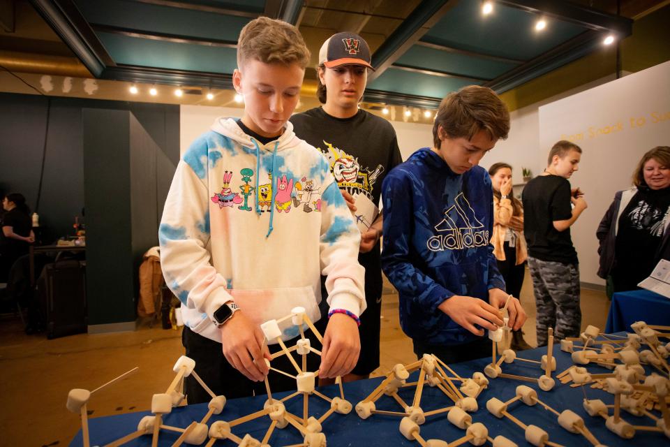 Creswell Middle School students Brock Cranmer, left, Colden Clark and Kayla Hugh build structures with marshmallows and possible sticks during a middle school career exploration fair with Connected Lane County Thursday, Nov. 10, 2022, in Eugene.