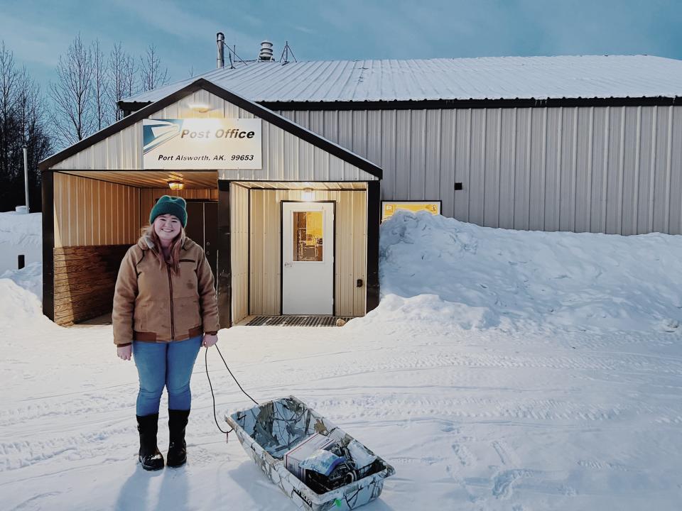 salina walking to the post office with her sled