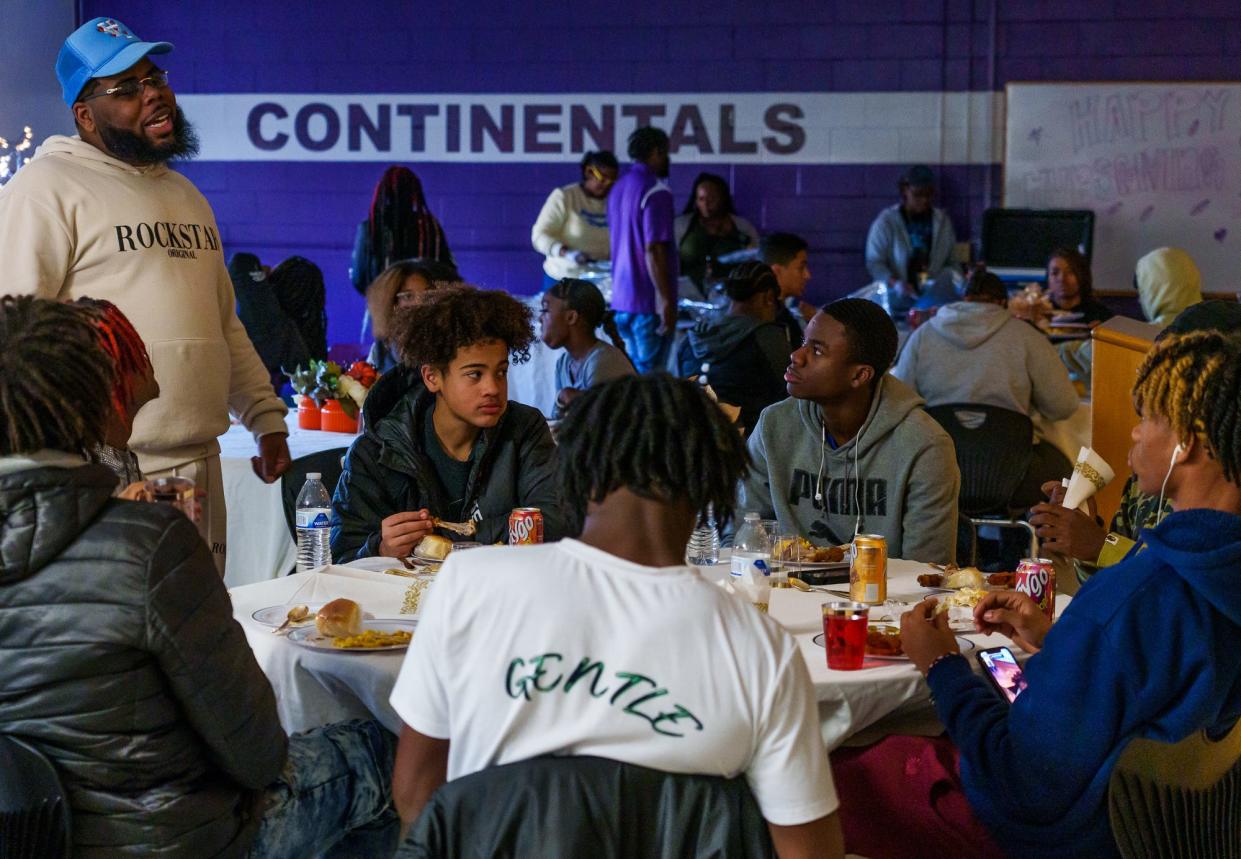 Brandon Buckley (left), coordinator of The HUB, speaks with George Washington High School students Tuesday, Nov. 22, 2022, while they enjoy a Thanksgiving meal. The meal, dubbed Hubsgiving, is an experience offered to students who participate in the school club that offers positive activities often about creating community and keeping kids engaged.